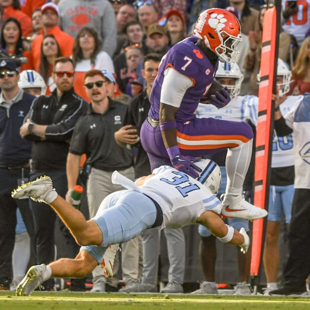 Clemson Tigers running back Phil Mafah leaps over The Citadel Bulldogs defensive back Cale Williams