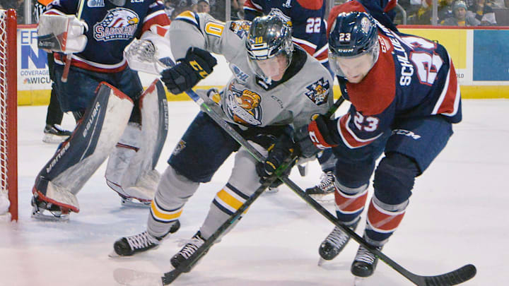 Erie Otters forward Carey Terrance, center, and Saginaw Spirit defenseman Pacey Schlueting battle for the puck during the first period on Oct. 23, 2021, at Erie Insurance Arena in Erie. It was the first game back on home ice after 594 days away due to the pandemic.

P7otters102321