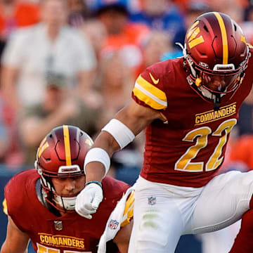 Sep 17, 2023; Denver, Colorado, USA; Denver Broncos quarterback Russell Wilson (3) slides for a first down against Washington Commanders safety Darrick Forrest (22) and linebacker Cody Barton (57) in the fourth quarter at Empower Field at Mile High. Mandatory Credit: Isaiah J. Downing-Imagn Images