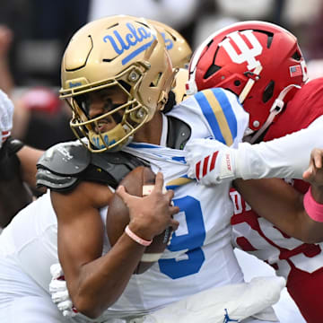 Oct 25, 2025; Bloomington, Indiana, USA; Indiana Hoosiers defensive lineman Tyrique Tucker (95) brings down UCLA Bruins quarterback Nico Iamaleava (9) during the first half at Memorial Stadium. Mandatory Credit: Robert Goddin-Imagn Images