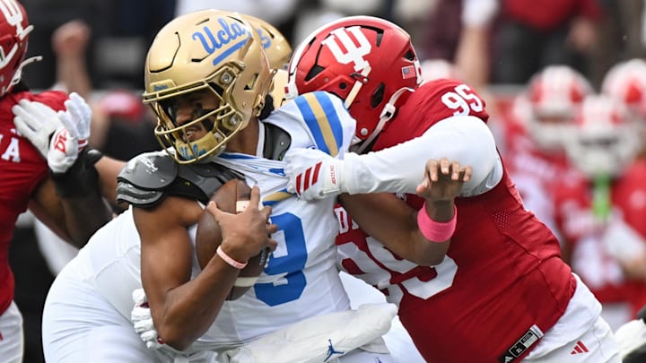 Oct 25, 2025; Bloomington, Indiana, USA; Indiana Hoosiers defensive lineman Tyrique Tucker (95) brings down UCLA Bruins quarterback Nico Iamaleava (9) during the first half at Memorial Stadium. Mandatory Credit: Robert Goddin-Imagn Images