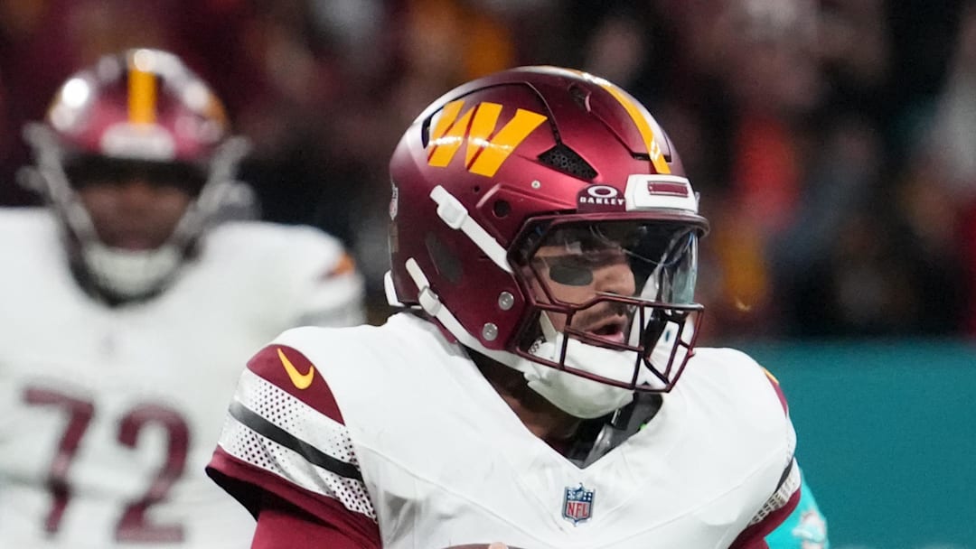 Washington Commanders quarterback Marcus Mariota carries the ball against the Miami Dolphins.
