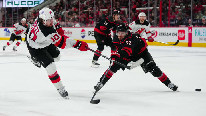 Jan 25, 2024; Raleigh, North Carolina, USA; New Jersey Devils right wing Alexander Holtz (10) takes a shot against Carolina Hurricanes defenseman Brett Pesce (22) during the second period at PNC Arena. Mandatory Credit: James Guillory-USA TODAY Sports