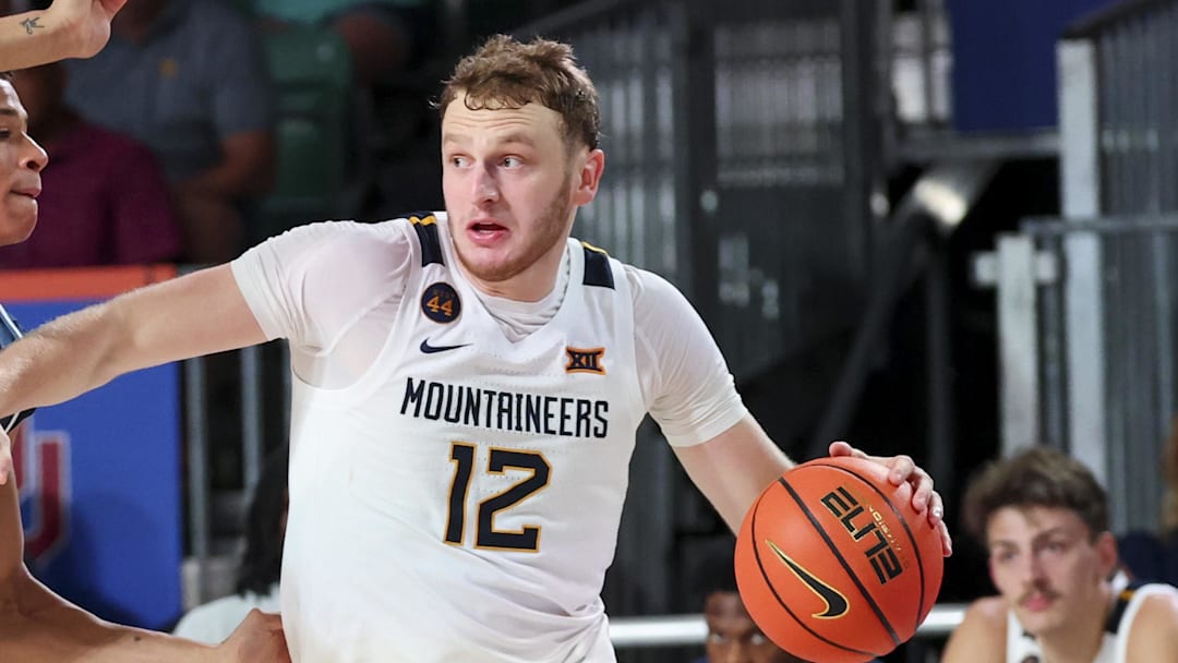 Nov 29, 2024; Paradise Island, Bahamas, BHS;  West Virginia Mountaineers guard Tucker DeVries (12) drives to the basket as Arizona Wildcats forward Carter Bryant (9) defends during the second half at Imperial Arena at the Atlantis resort.  Mandatory Credit: Kevin Jairaj-Imagn Images