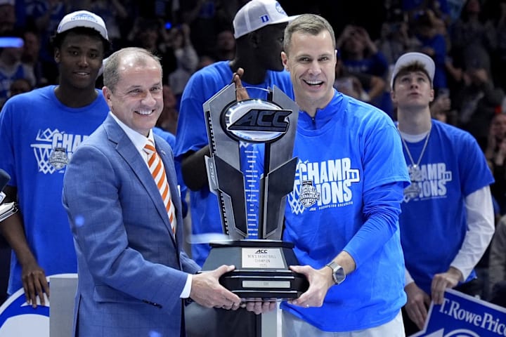ACC commissioner Jim Phillips hands the championship trophy to Duke Blue Devils head coach Jon Scheyer. 