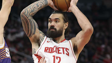 Dec 5, 2025; Houston, Texas, USA; Houston Rockets center Steven Adams (12) controls the ball as Phoenix Suns guard Collin Gillespie (12) defends during the first half at Toyota Center. Mandatory Credit: Troy Taormina-Imagn Images