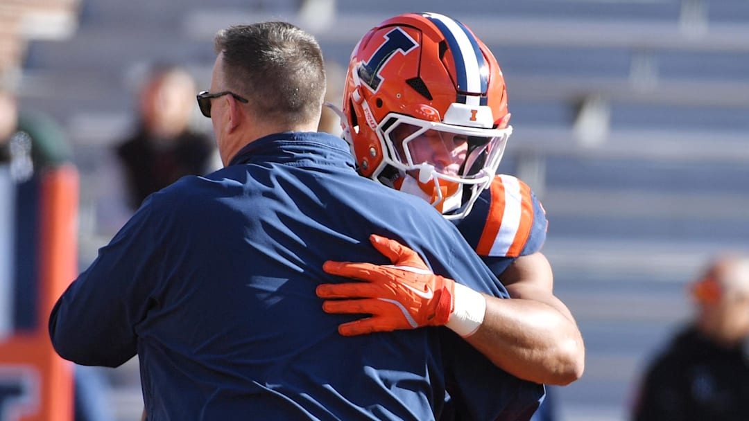 Nov 1, 2025; Champaign, Illinois, USA;  Illinois Fighting Illini head coach Bret Bielema greets player running back Ca'Lil Valentine (5) before an NCAA game against the Rutgers Scarlet Knights at Memorial Stadium. Mandatory Credit: Ron Johnson-Imagn Images