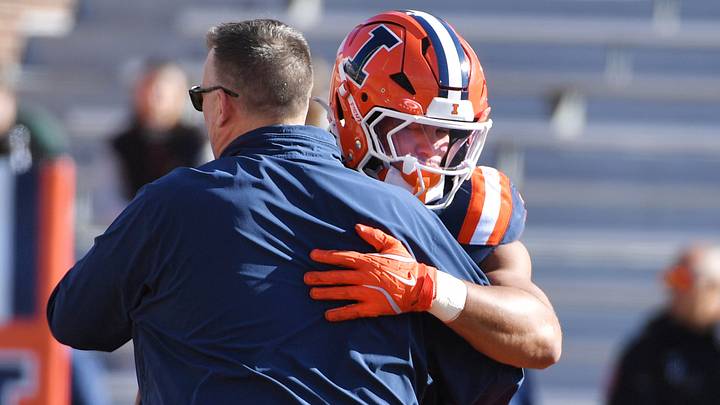Nov 1, 2025; Champaign, Illinois, USA;  Illinois Fighting Illini head coach Bret Bielema greets player running back Ca'Lil Valentine (5) before an NCAA game against the Rutgers Scarlet Knights at Memorial Stadium. Mandatory Credit: Ron Johnson-Imagn Images