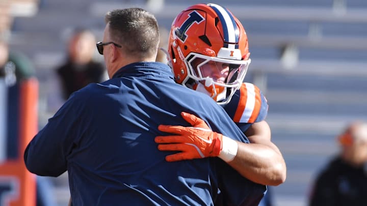 Nov 1, 2025; Champaign, Illinois, USA;  Illinois Fighting Illini head coach Bret Bielema greets player running back Ca'Lil Valentine (5) before an NCAA game against the Rutgers Scarlet Knights/