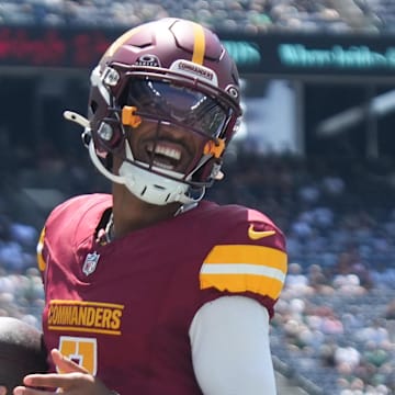 Aug 10, 2024; East Rutherford, New Jersey, USA; Washington Commanders quarterback Jayden Daniels (5) rushes for a touchdown during the first quarter against the New York Jets at MetLife Stadium. Mandatory Credit: Lucas Boland-Imagn Images