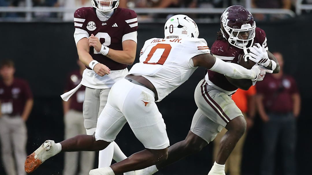 Oct 25, 2025; Starkville, Mississippi, USA; Mississippi State Bulldogs running back Davon Booth (6) runs the ball  as Texas Longhorns linebacker Anthony Hill Jr. (0) makes the tackle during the third quarter at Davis Wade Stadium at Scott Field. Mandatory Credit: Petre Thomas-Imagn Images