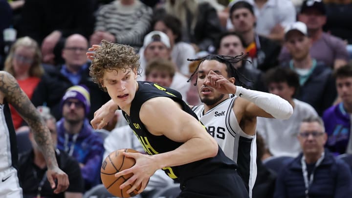 Mar 27, 2024; Salt Lake City, Utah, USA; Utah Jazz forward Lauri Markkanen (23) spins to the basket against San Antonio Spurs guard Tre Jones (33) during the fourth quarter at Delta Center. Mandatory Credit: Rob Gray-USA TODAY Sports