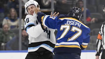 Nov 7, 2024; St. Louis, Missouri, USA; Utah Hockey Club defenseman Maveric Lamoureux (10) fights St. Louis Blues defenseman Pierre-Olivier Joseph (77) during the second period at Enterprise Center. Mandatory Credit: Jeff Le-Imagn Images