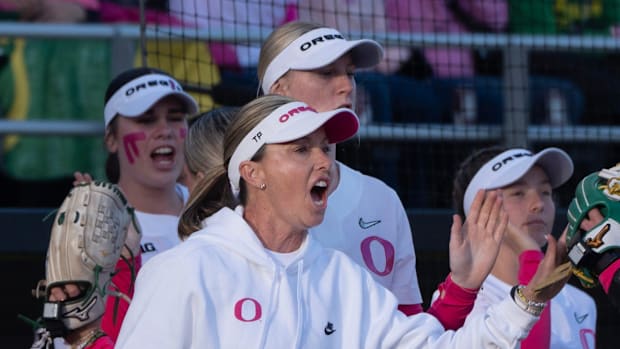 Oregon coach Melyssa Lombardi, center, cheers her team during the first inning against Michigan at Jane Sanders Stadium.