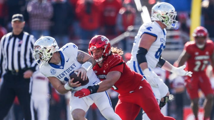 Louisville Cardinals defensive lineman Ashton Gillotte (9) brings down Kentucky Wildcats quarterback Devin Leary (13) for a sack in the first half Saturday. Nov. 25, 2023.