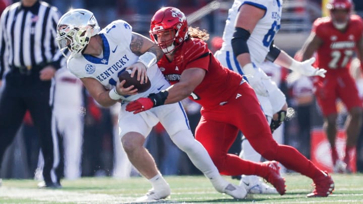 Louisville Cardinals defensive lineman Ashton Gillotte (9) brings down Kentucky Wildcats quarterback Devin Leary (13) for a sack in the first half Saturday. 