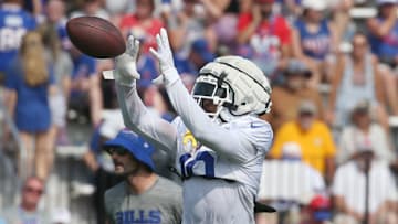 Bills wide receiver K.J. Hamler pulls in a pass across the middle during route drills.