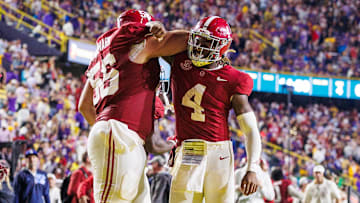 Nov 9, 2024; Baton Rouge, Louisiana, USA;  Alabama Crimson Tide quarterback Jalen Milroe (4) celebrates a touchdown with offensive lineman Geno VanDeMark (56) against the LSU Tigers during the second half at Tiger Stadium. Mandatory Credit: Stephen Lew-Imagn Images