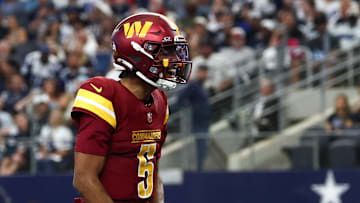 Oct 19, 2025; Arlington, Texas, USA; Washington Commanders quarterback Jayden Daniels (5) celebrates after scoring a touchdown against the Dallas Cowboys during the second quarter of the game at AT&T Stadium. Mandatory Credit: Kevin Jairaj-Imagn Images