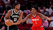 Oct 27, 2025; Houston, Texas, USA; Brooklyn Nets center Nic Claxton (33) handles the ball against Houston Rockets guard Amen Thompson (1) during the first quarter at Toyota Center. Mandatory Credit: Erik Williams-Imagn Images
