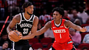 Oct 27, 2025; Houston, Texas, USA; Brooklyn Nets center Nic Claxton (33) handles the ball against Houston Rockets guard Amen Thompson (1) during the first quarter at Toyota Center. Mandatory Credit: Erik Williams-Imagn Images
