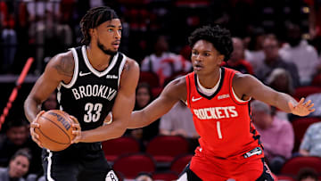 Oct 27, 2025; Houston, Texas, USA; Brooklyn Nets center Nic Claxton (33) handles the ball against Houston Rockets guard Amen Thompson (1) during the first quarter at Toyota Center. Mandatory Credit: Erik Williams-Imagn Images

