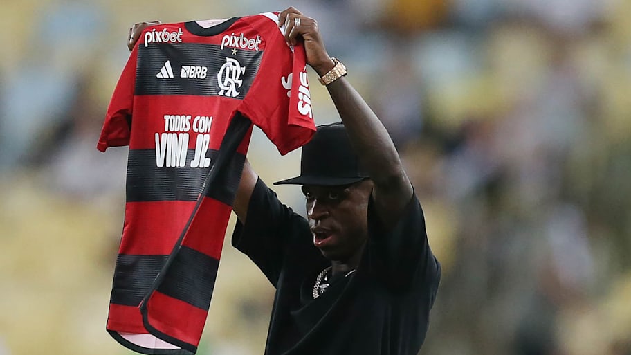 Vinicius Junior holding up a Flamengo shirt.