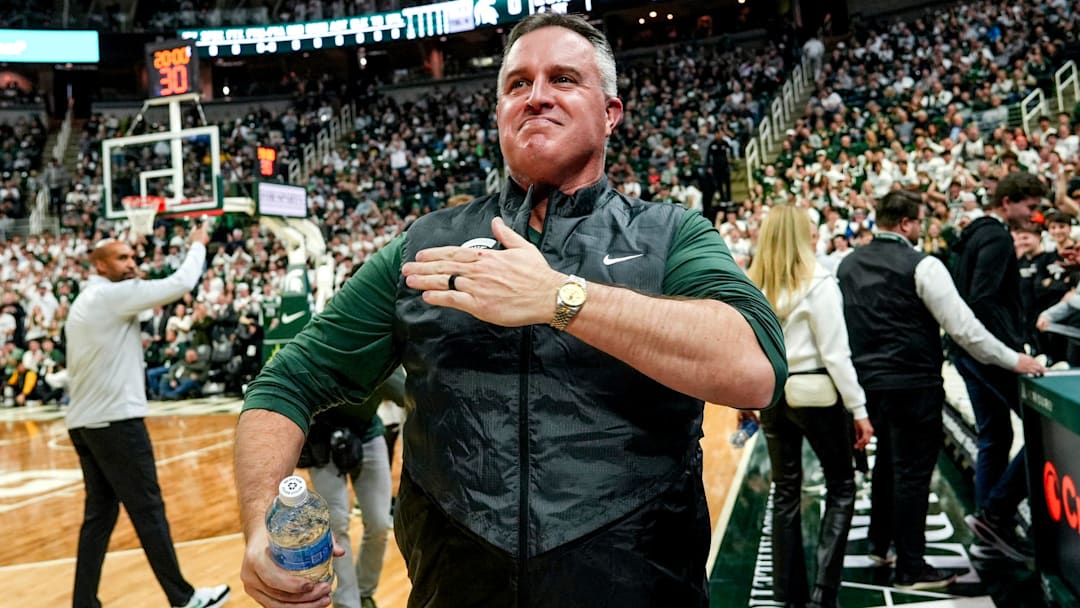 Michigan State's new football coach Pat Fitzgerald pats his heart at the crowd in attendance for the Spartans basketball game against Iowa on Tuesday, Dec. 2, 2025, at the Breslin Center in East Lansing.