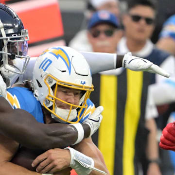 Nov 10, 2024; Inglewood, California, USA;  Los Angeles Chargers quarterback Justin Herbert (10) is stopped by Tennessee Titans linebacker Kenneth Murray Jr. (56) in the second half at SoFi Stadium. Mandatory Credit: Jayne Kamin-Oncea-Imagn Images