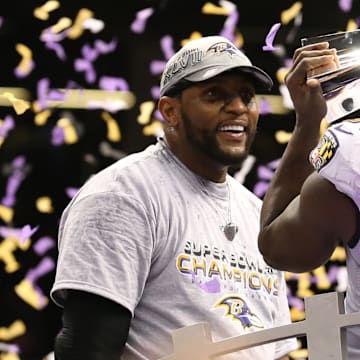 Baltimore Ravens safety Ed Reed kisses the Vince Lombardi Trophy as linebacker Ray Lewis smiles.
