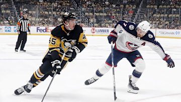 Oct 4, 2024; Pittsburgh, Pennsylvania, USA;  Pittsburgh Penguins defenseman Harrison Brunicke (45) skates in on goal against Columbus Blue Jackets center Sean Kuraly (7) during the first period at PPG Paints Arena. Mandatory Credit: Charles LeClaire-Imagn Images