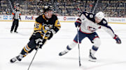 Oct 4, 2024; Pittsburgh, Pennsylvania, USA;  Pittsburgh Penguins defenseman Harrison Brunicke (45) skates in on goal against Columbus Blue Jackets center Sean Kuraly (7) during the first period at PPG Paints Arena. Mandatory Credit: Charles LeClaire-Imagn Images