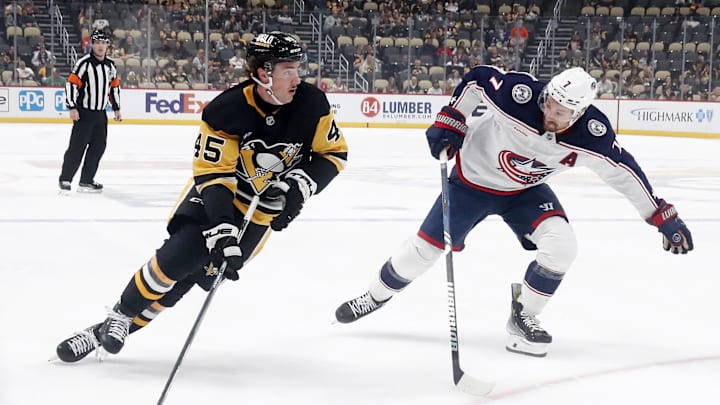 Oct 4, 2024; Pittsburgh, Pennsylvania, USA;  Pittsburgh Penguins defenseman Harrison Brunicke (45) skates in on goal against Columbus Blue Jackets center Sean Kuraly (7) during the first period at PPG Paints Arena. Mandatory Credit: Charles LeClaire-Imagn Images