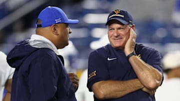 Oct 3, 2025; Provo, Utah, USA; West Virginia Mountaineers head coach Rich Rodriguez (right) speaks with Brigham Young Cougars head coach Kalani Sitake before the game at LaVell Edwards Stadium. Mandatory Credit: Rob Gray-Imagn Images