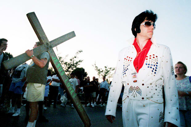 Elvis impersonator Don Obusek, right, walks along Elvis Presley Blvd. with evangelist and Elvis fan Larry Gross.