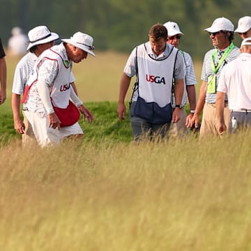 Officials, caddies and golfers search for the ball of Rasmus Neergaard-Petersen on the 14th hole during the first round of the U.S. Open. 