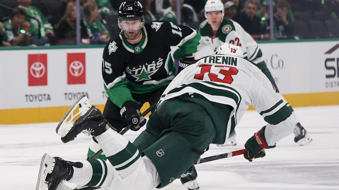 Apr 18, 2026; Dallas, Texas, USA;Minnesota Wild center Yakov Trenin (13) is tripped while skating with the puck against Dallas Stars center Colin Blackwell (15) in the third period in game one of the first round of the 2026 Stanley Cup Playoffs at American Airlines Center. Mandatory Credit: Thomas Shea-Imagn Images