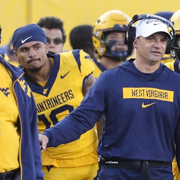 Sep 7, 2024; Morgantown, West Virginia, USA; West Virginia Mountaineers head coach Neal Brown talks with West Virginia Mountaineers quarterback Garrett Greene (6) after he threw for a touchdown during the second quarter against the Albany Great Danes at Mountaineer Field at Milan Puskar Stadium. 