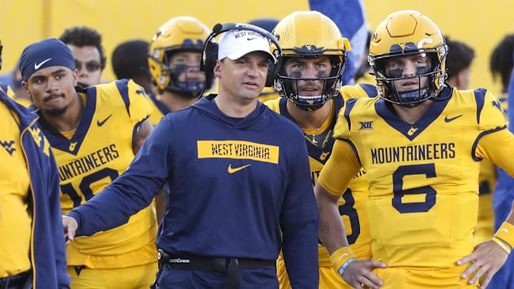 Sep 7, 2024; Morgantown, West Virginia, USA; West Virginia Mountaineers head coach Neal Brown talks with West Virginia Mountaineers quarterback Garrett Greene (6) after he threw for a touchdown during the second quarter against the Albany Great Danes at Mountaineer Field at Milan Puskar Stadium. 