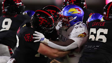 Oct 11, 2025; Lubbock, Texas, USA;  Texas Tech Red Raiders offensive center Sheridan Wilson blocks Kansas Jayhawks defensive tackle Tommy Dunn Jr. (92) in the second half at Jones AT&T Stadium. Mandatory Credit: Michael C. Johnson-Imagn Images