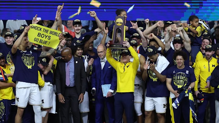 Apr 6, 2026; Indianapolis, IN, USA; Michigan Wolverines head coach Dusty May celebrates with the trophy after defeating the UConn Huskies in the national championship of the Final Four of the men's 2026 NCAA Tournament at Lucas Oil Stadium. Mandatory Credit: Trevor Ruszkowski-Imagn Images