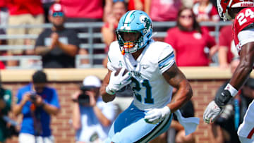 Sep 14, 2024; Norman, Oklahoma, USA;  Tulane Green Wave running back Makhi Hughes (21) runs with the ball as Oklahoma Sooners linebacker Samuel Omosigho (24) defends during the first half at Gaylord Family-Oklahoma Memorial Stadium.