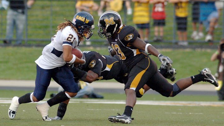 Sep 2, 2006; Columbia, MO, USA;  Murray State Racers wide receiver (21) Jonathan Eiland is tackled by Missouri Tigers (13) Cornelius Brown and linebacker (33) Dedrick Harrington in the first quarter at Memorial Stadium/Faurot Field in Columbia, MO.  Mandatory Credit: Denny Medley - Imagn Images Copyright (c) Denny Medley
