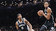Oct 24, 2025; Brooklyn, New York, USA;  Brooklyn Nets center Nic Claxton (33) jumps in between guard Terance Mann (14) and Cleveland Cavaliers guard Jaylon Tyson (20) to grab a rebound in the third quarter at Barclays Center. Mandatory Credit: Wendell Cruz-Imagn Images
