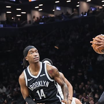 Oct 24, 2025; Brooklyn, New York, USA;  Brooklyn Nets center Nic Claxton (33) jumps in between guard Terance Mann (14) and Cleveland Cavaliers guard Jaylon Tyson (20) to grab a rebound in the third quarter at Barclays Center. Mandatory Credit: Wendell Cruz-Imagn Images