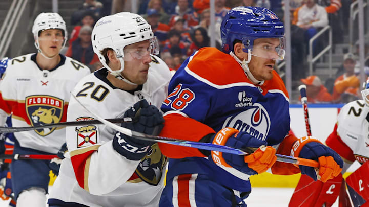 Mar 19, 2026; Edmonton, Alberta, CAN; Florida Panthers defensemen Mike Benning (20) and Edmonton Oilers forward Jack Roslovic (28) skate after the puck during the third period at Rogers Place. Mandatory Credit: Perry Nelson-Imagn Images