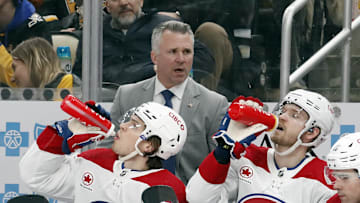 Feb 22, 2024; Pittsburgh, Pennsylvania, USA; Montreal Canadiens head coach Martin St. Louis (top) looks on from the bench against the Pittsburgh Penguins during the second period at PPG Paints Arena. The Penguins won 4-1. Mandatory Credit: Charles LeClaire-Imagn Images