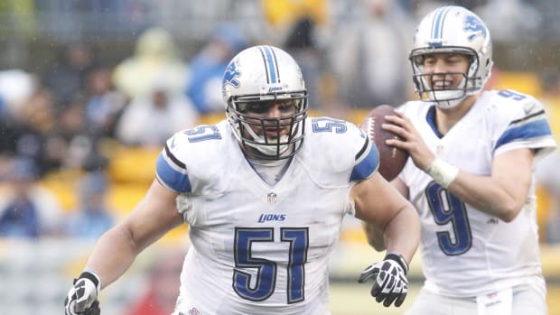 Detroit Lions center Dominic Raiola (51) blocks at the line of scrimmage in front of quarterback Matthew Stafford (9)