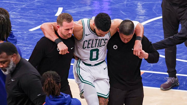 Boston Celtics forward Jayson Tatum is helped off the court by after an injury.