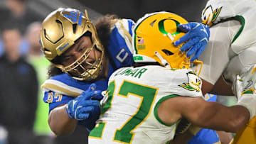 Sep 28, 2024; Pasadena, California, USA; UCLA Bruins defensive lineman Jay Toia (93) tackles Oregon Ducks running back Jayden Limar (27) during the fourth quarter at Rose Bowl. Mandatory Credit: Robert Hanashiro-Imagn Images